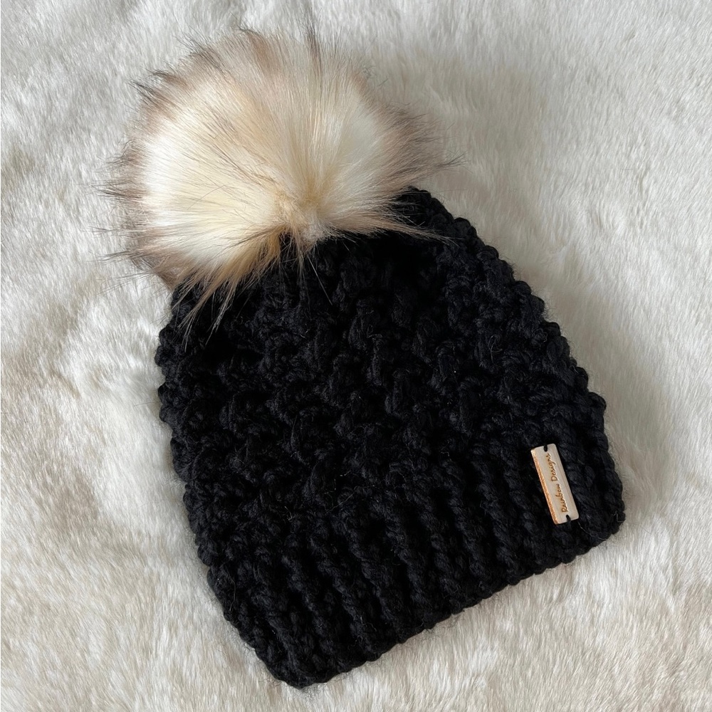 Black beanie with cream, light brown tipped faux fur pompom. NWOT, never worn!